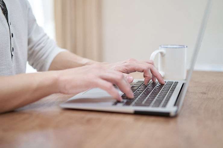 Person typing on laptop.
