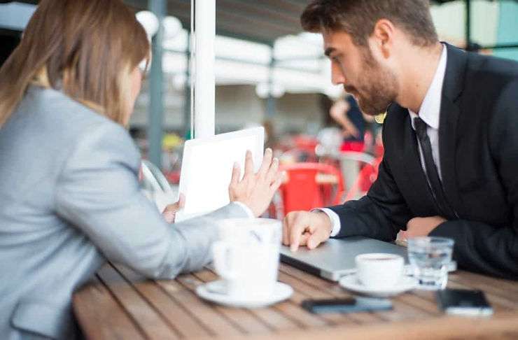 Coworkers working over coffee. 